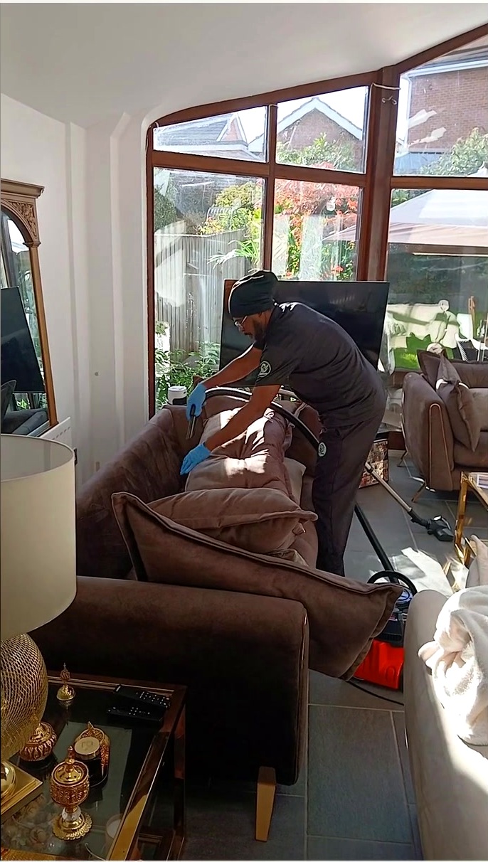 Good Hands cleaner working on a sofa with professional upholstery cleaning equipment
